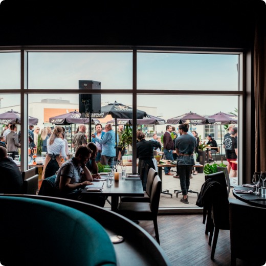 ambiance-siam-dix30.jpg La terrasse du Siam Dix30 vue de l'intérieur avec plusieurs personnes qui discutent lors d'un 5 à 7.