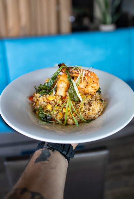 riz-thai-crevette.jpg Un homme tient un plat thaïlandais du restaurant Siam avec riz et crevette.