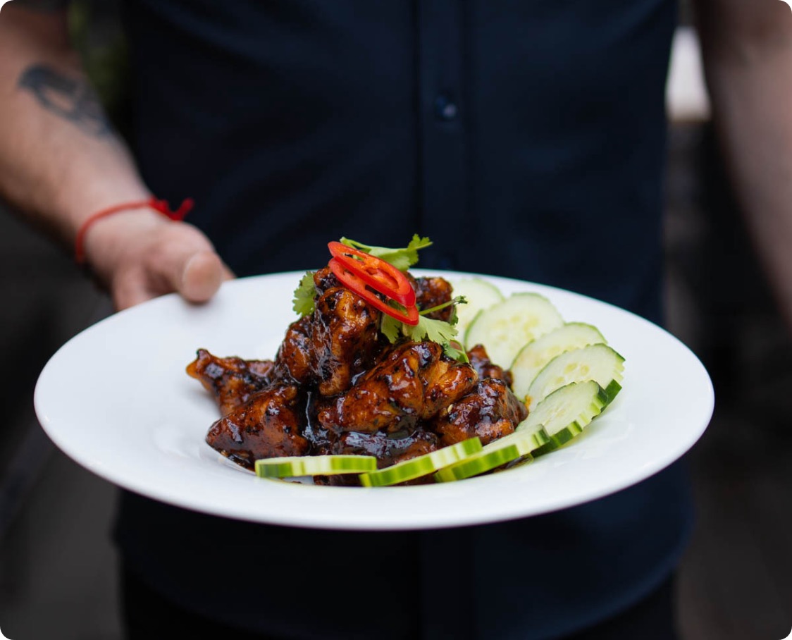 Un homme tient un plat de poulet thaïlandais traditionnel du restaurant Siam Saint-Jean-sur-Richelieu.