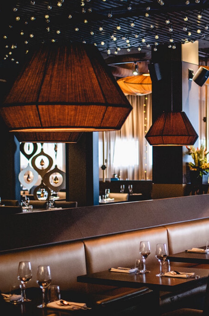 La salle à manger du restaurant Siam Dix30 dans une ambiance intime et feutrée avec lumières suspendus et tables dressées.