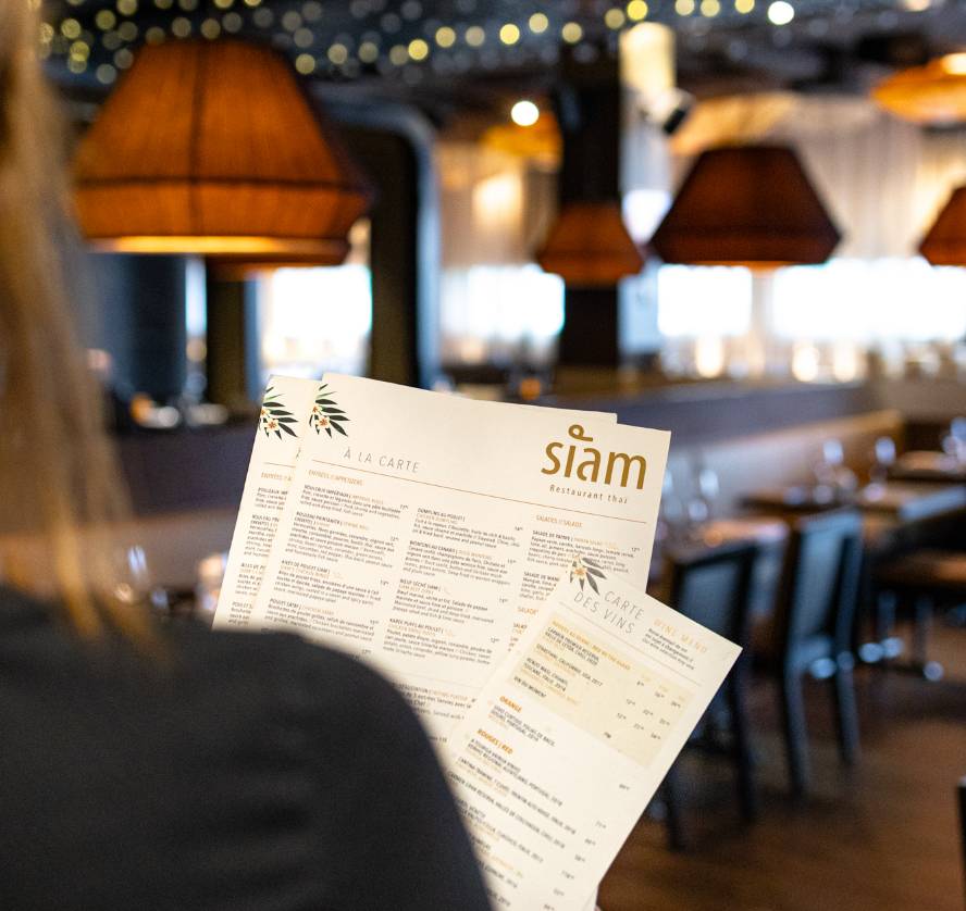 menus-siam.jpg Une femme de dos tient des menus du restaurant Siam à Saint-Jean-sur-Richelieu.