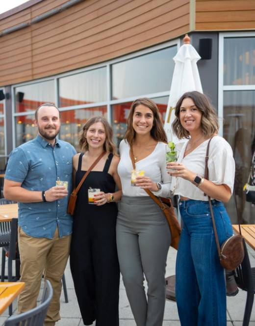 Trois jeunes femmes et un jeune homme devant le restaurant Siam Dix30 avec un cocktail dans la main.