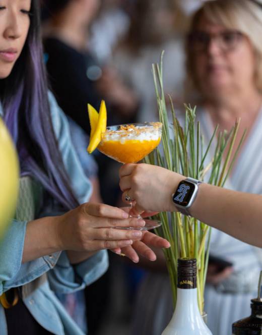 Une cliente du Siam tient un cocktail à la mangue.