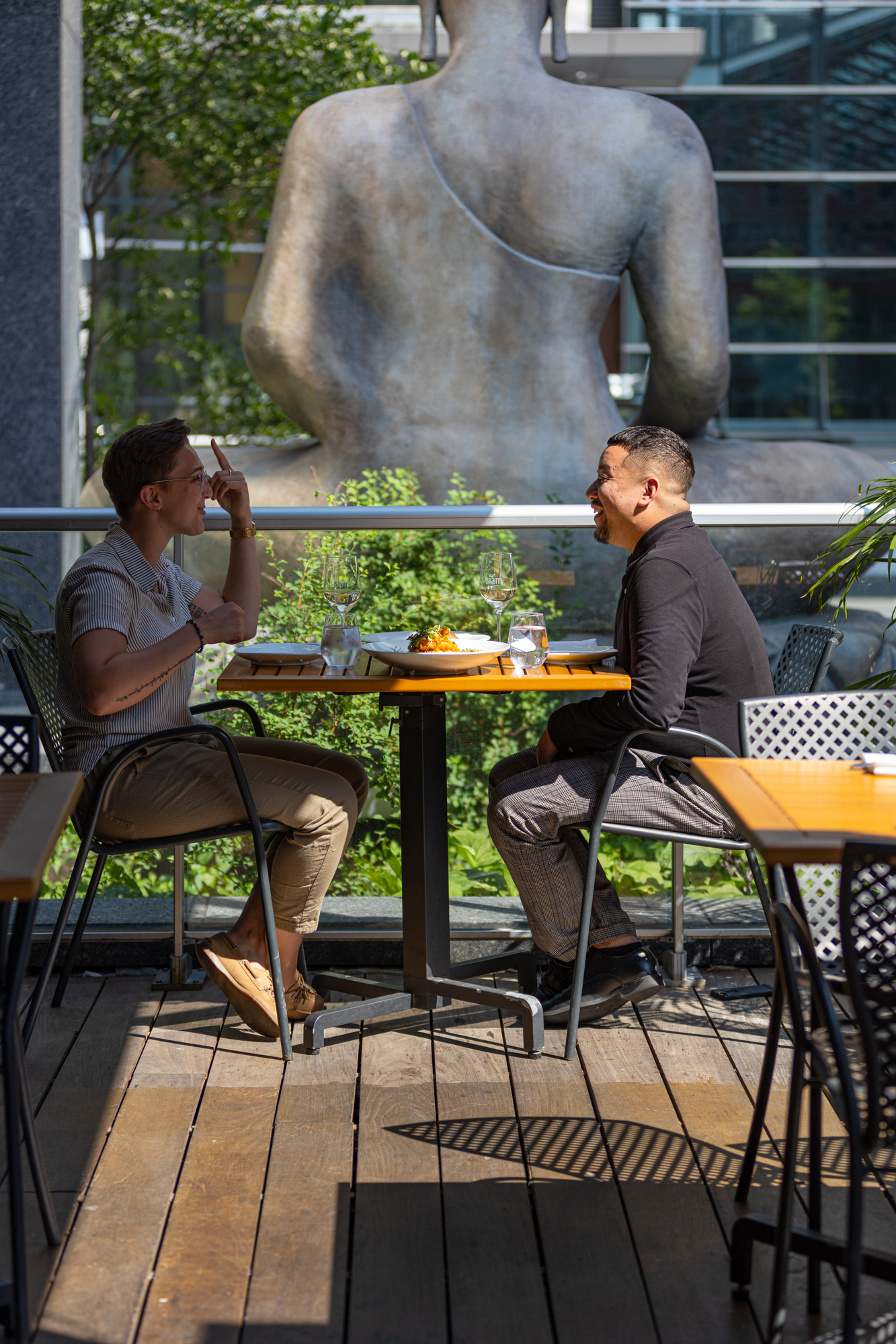 Deux hommes discutent autour d'un repas sur la terrasse du Siam